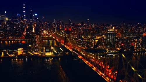 Red and yellow illumination of the Queensboro Bridge at night. Dazzling scenery of New York, the USA