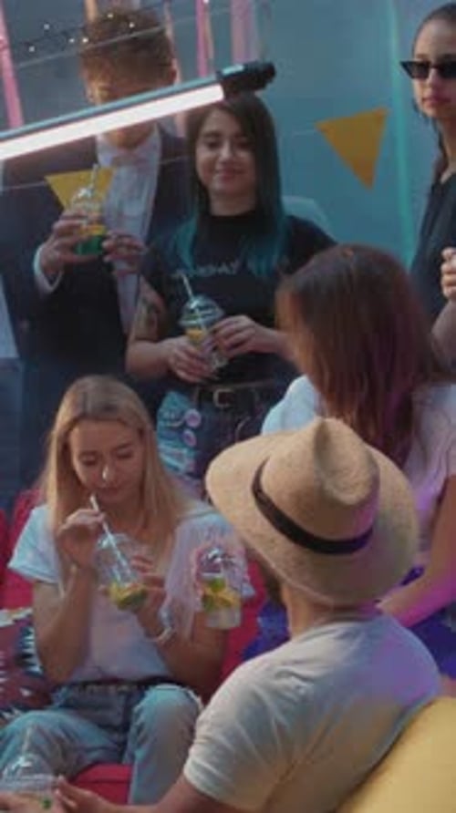 Young Adults Enjoying Evening Party with Drinks