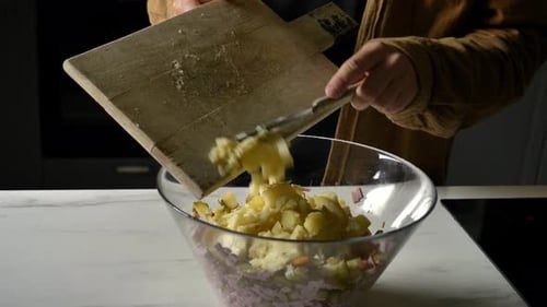 Man cutting potatoes for salad at kitchen