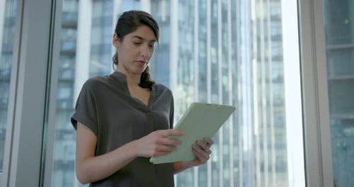 Femme d'affaires travaillant sur la technologie des tablettes numériques, debout au bureau