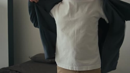 Man Putting on Fleece Jacket Indoors