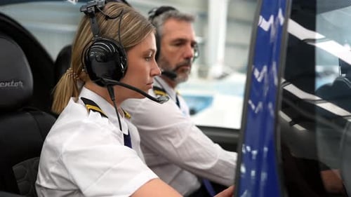Female student pilot training with instructor in a helicopter flight simulator