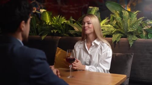 Joyeux jeune couple buvant du vin mousseux profitant d'un rendez-vous romantique en dînant dans un restaurant
