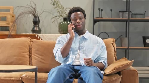 Man Talking on Phone While Sitting on Couch
