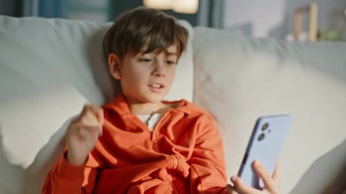 Boy Chatting on a Smartphone While Relaxing at Home