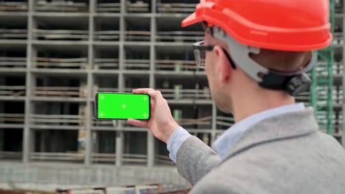 Man in Hardhat Holds Green Screen Phone