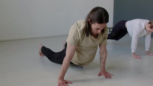 Two Partners Stretching Together in Dance Studio before Rehearsal