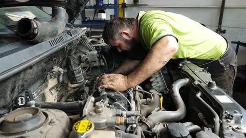 Male Repairer Making Maintenance of Car at Garage Adult Auto Mechanic Working Under Hood of Vehicle