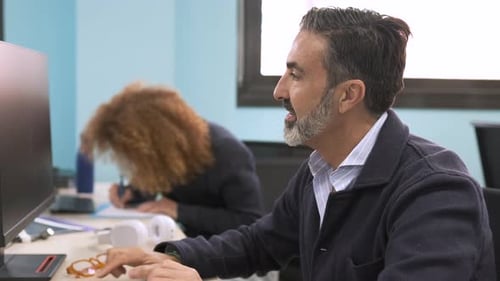 Happy Confident Mature Businessman Using Computer in Office