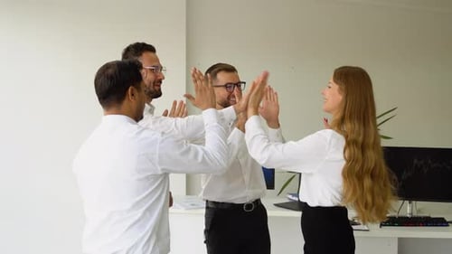 Team Celebrating Success with High Fives in Office