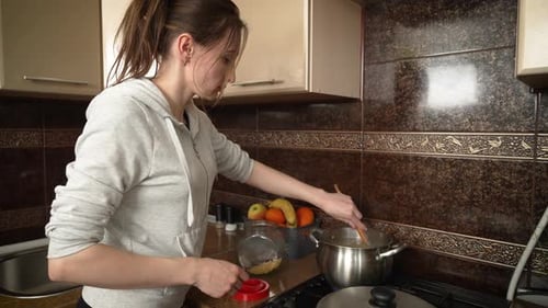 Woman Cooking Meal in Cozy Kitchen