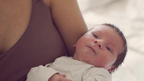 Newborn Baby Held Close Up in Arms