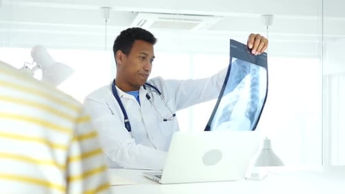 Doctor Examines X-Ray and Consults with Patient