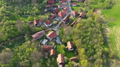 Aerial View of a Small Countryside Village. Flying Over Village Street and House Roofs