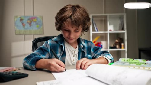 Boy Draws At Desk Doing Homework At Home