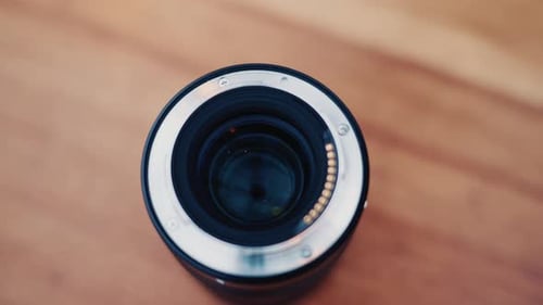 Nahaufnahme eines in der Hand gehaltenen Kameraobjektivs mit weichem Hintergrund-Bokeh