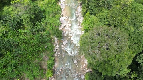 Water cascades over textured rocks. Aerial view
