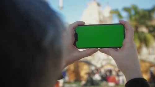 Young Man Holding Phone Chroma Key Screen on the Street Closeup Male with Green Screen on Smart