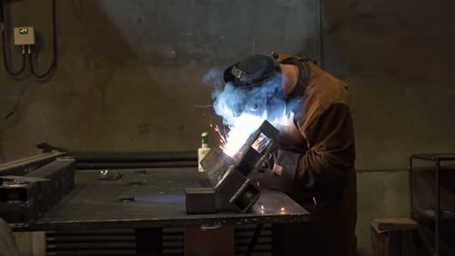 Professional factory craftsmen while working using modern industrial equipment, bright sparks and
