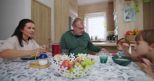 Family Eating Breakfast at Table in Home Kitchen