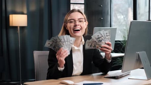 Aufgeregte Geschäftsfrau zeigt Geld, Währung, Dollar, Banknoten im Büro