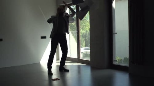 Upset man throwing papers while on phone indoors