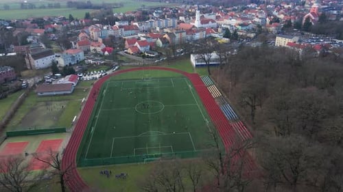 Aerial View of Stadium in Small Town Players Play Football on Soccer Field