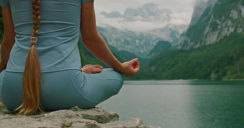 Close-up of a meditating woman posture, her hand in a mudra, symbolizing deep connection with nature