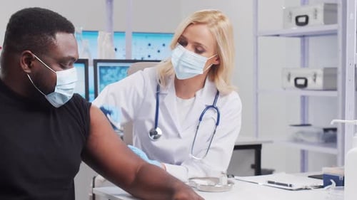 Doctor Giving Vaccine to Patient in Clinic