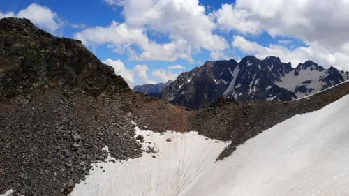 Scène alpine avec des pentes glacées, un bol de montagne majestueux avec des pentes d'éboulis abruptes sous un bleu clair