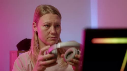 Young Adult Puts on Wireless Headphones Indoors