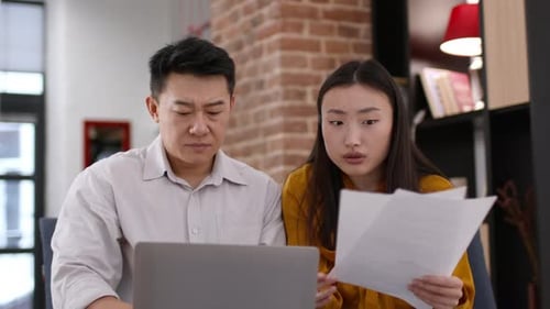 Coworkers Reviewing Data and Concerned at the Office