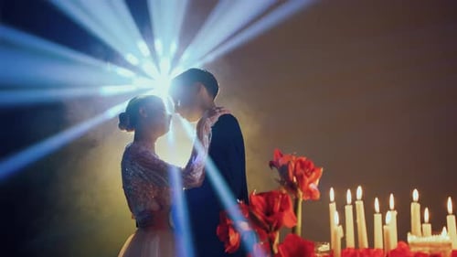 Couple Embracing Surrounded by Candles and Flowers