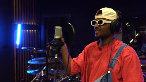 Young african american artist recording music in studio