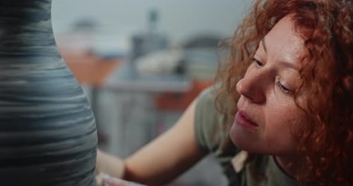 Woman Shaping Clay on Pottery Wheel in Studio