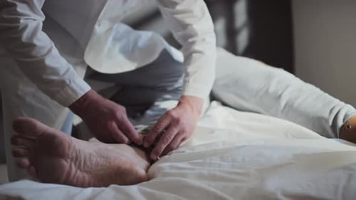 Doctor Securing Restraints on Patient's Legs