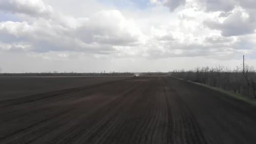 Blue tractor working on the field in Odessa in Ukraine during planting sunflower