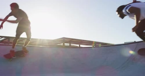 Young Adults Skateboarding at Skatepark on Sunny Day
