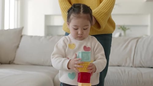 Asian Little Girl Playing with Building Blocks at Home