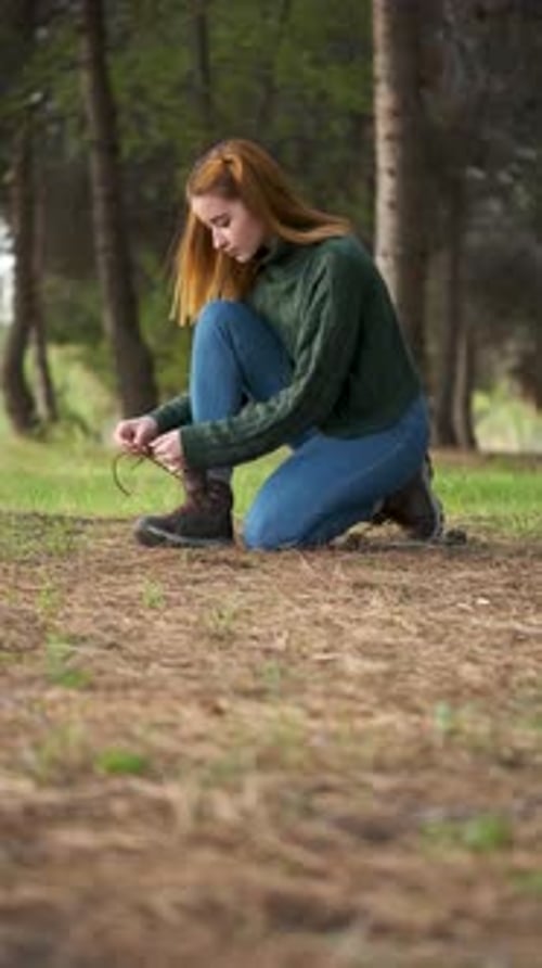 Woman Tying Shoe Laces in a Forest