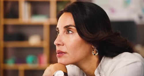 Thoughtful Woman Resting Chin on Hand at Work