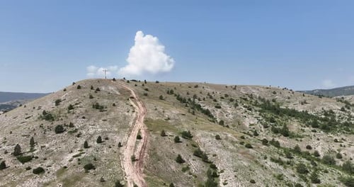 Cruz de Stian Religio situada en la cima de una montaña bajo un cielo azul