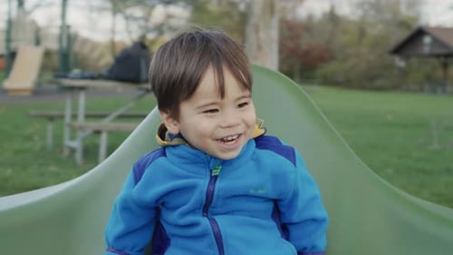 Carefree Asian Kid Rides on a Merrygoround Smiles and Enjoys a Walk