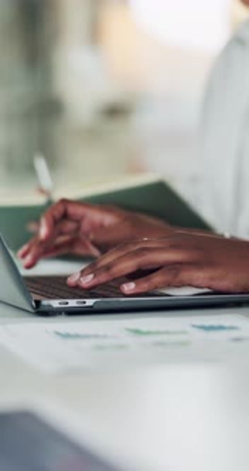 Hände, Laptop und grafische Unterlagen mit Tippen zur Dateneingabe, Mitarbeiter erfassen Informationen