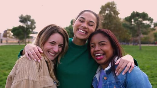 Three Friends Embracing and Laughing Outdoors