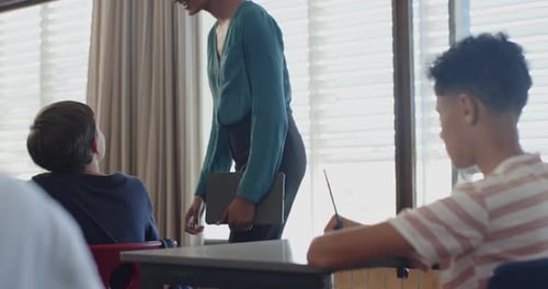 In school, teacher smiling and interacting with students in classroom setting