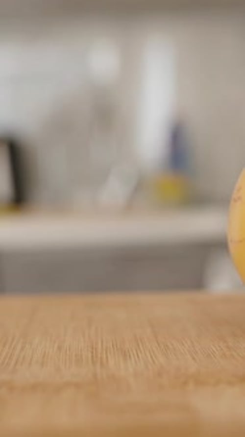 Vertical video. Vertical video. Pepino Fruit on Wooden Cutting Board by a Knife, Slider Close-Up,