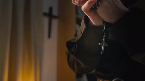 Close-up of Hands of Anonymous Religious Woman Clasping Black Rosary