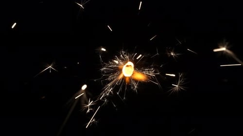 Sparkler Emitting Sparks of Light on Black Background