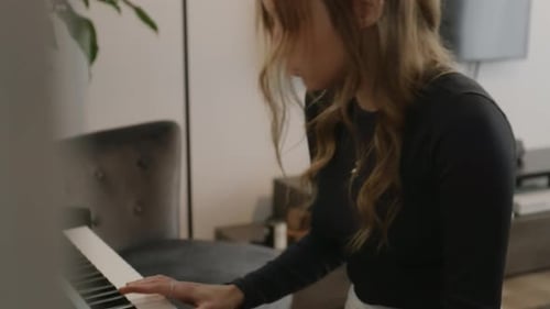 Woman plays piano in her modern living room